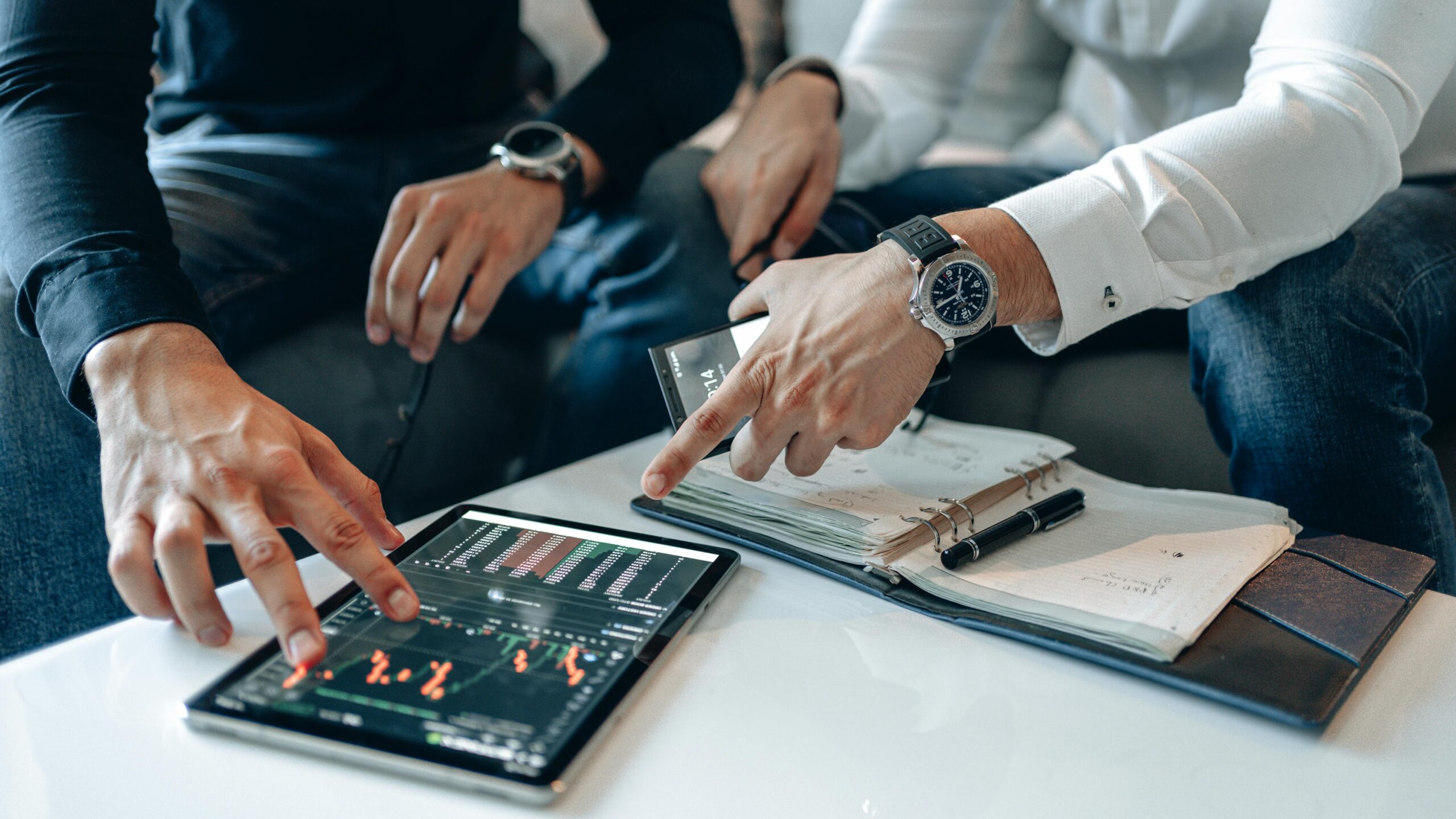 pexels photo 5833784 5833784 Men in business attire discussing financial data on a tablet indoors.
