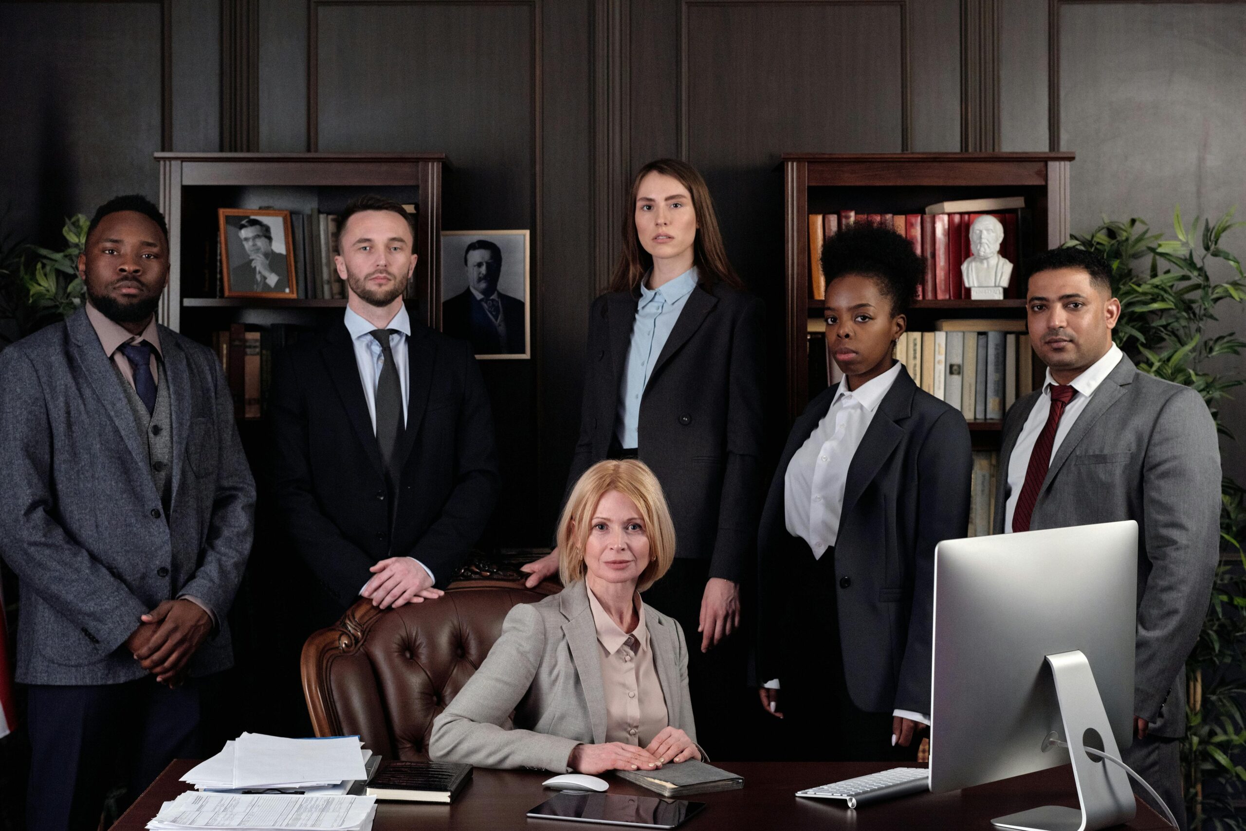 Noble Corporacion Financiera Diverse group of professionals in corporate attire posing confidently in an office environment.