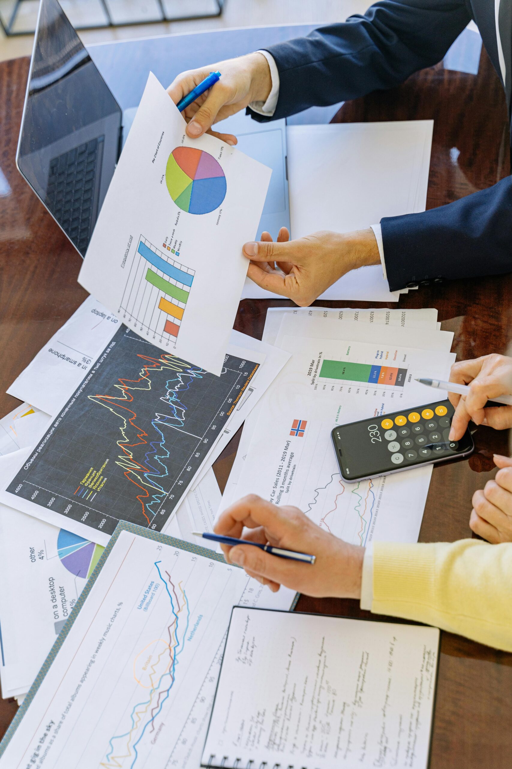 Eurocredit Mexico SAPI de CV SOFOM ENR Business professionals analyzing financial charts and graphs during a meeting.